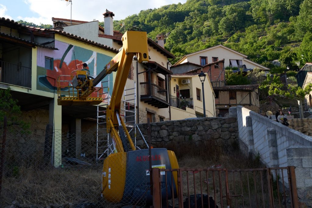 MOTS muralist on cherry picker painting a mural in Spain